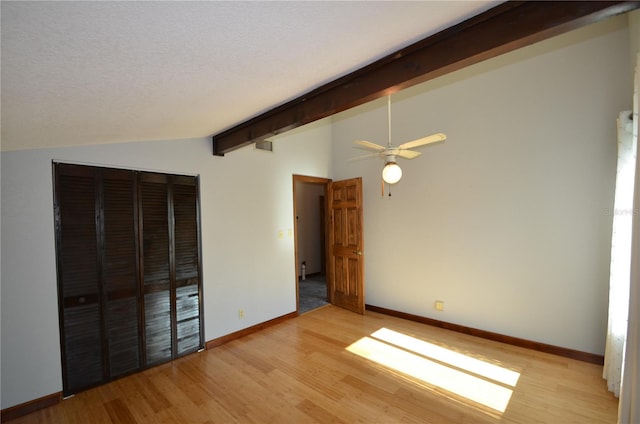 unfurnished bedroom with vaulted ceiling with beams, ceiling fan, a textured ceiling, and light wood-type flooring