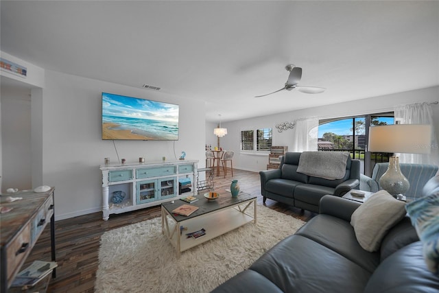 living room with ceiling fan and dark wood-type flooring