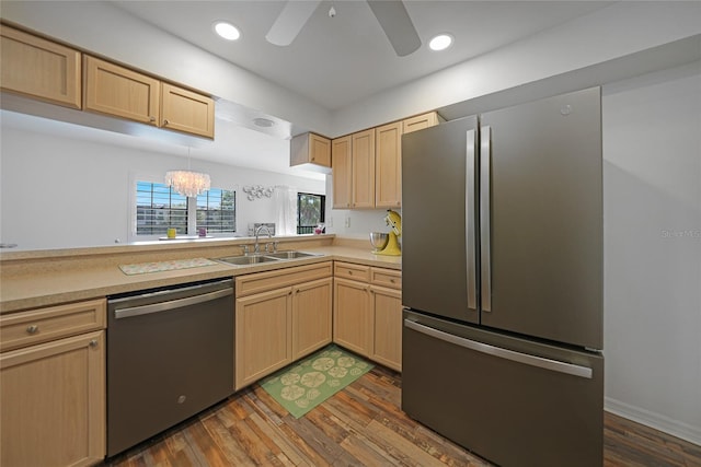 kitchen featuring sink, dark wood-type flooring, stainless steel appliances, light brown cabinetry, and ceiling fan with notable chandelier