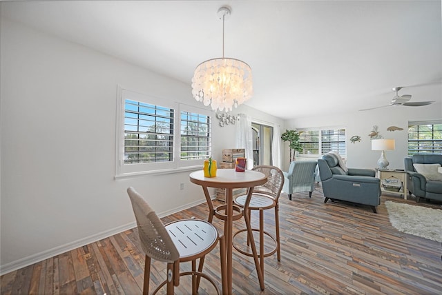 dining space featuring ceiling fan with notable chandelier and dark hardwood / wood-style floors