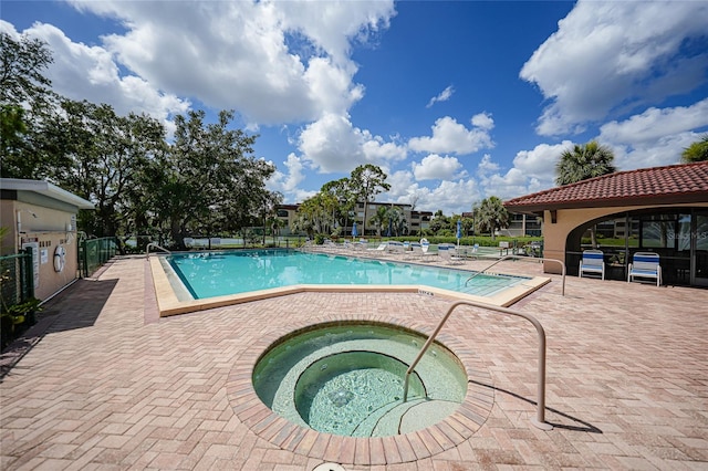 view of swimming pool with a patio area and a community hot tub