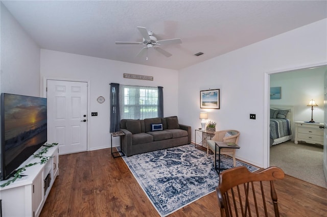 living room with ceiling fan and dark hardwood / wood-style flooring