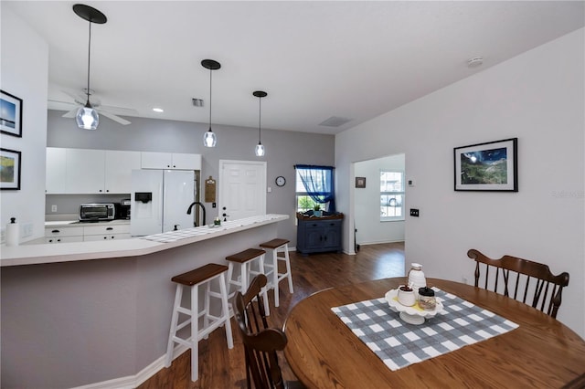 dining room with ceiling fan and dark wood-type flooring