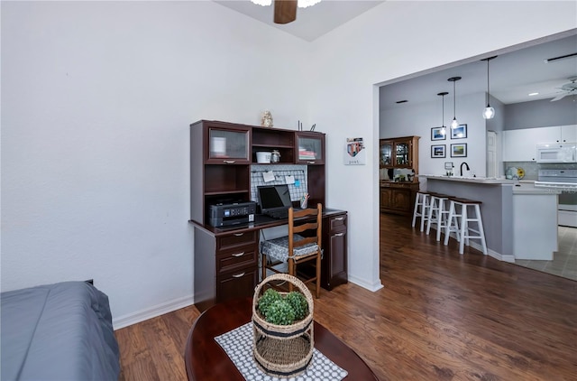 office area with dark hardwood / wood-style floors, ceiling fan, and sink