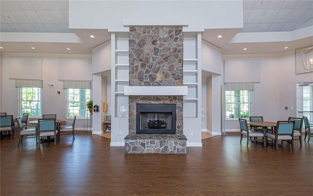 living room with a wealth of natural light, a fireplace, and a towering ceiling