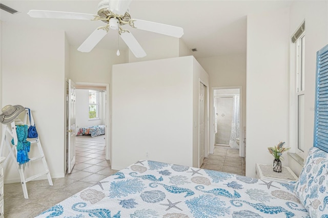 bedroom featuring light tile patterned floors, ensuite bath, and ceiling fan