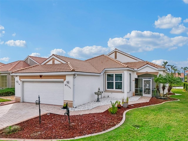 mediterranean / spanish home featuring a front yard and a garage