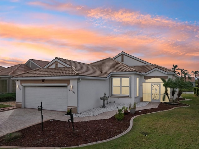 view of front of home with a garage and a lawn