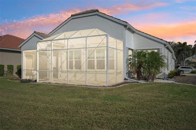 outdoor structure at dusk featuring a lawn