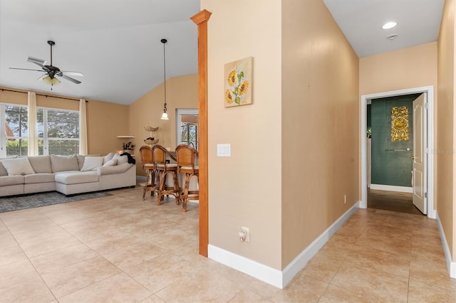 hallway featuring light tile patterned floors and vaulted ceiling