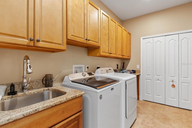 washroom featuring cabinets, washer and clothes dryer, and sink