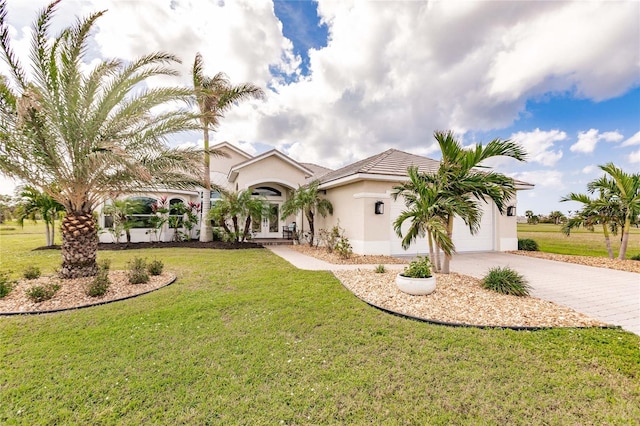 mediterranean / spanish-style home featuring a garage and a front yard