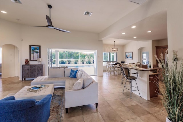 living room featuring ceiling fan, sink, and light tile patterned floors