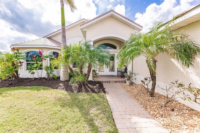 property entrance with a yard and french doors