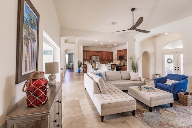 tiled living room featuring ceiling fan and french doors