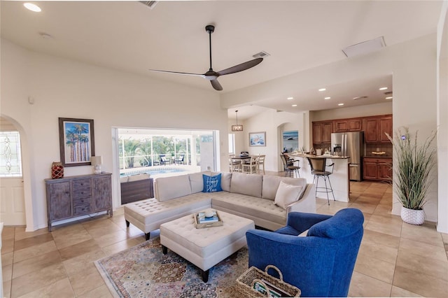 tiled living room featuring ceiling fan and a towering ceiling