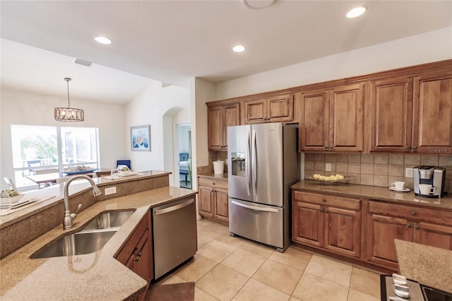 kitchen featuring sink, stainless steel appliances, an inviting chandelier, backsplash, and decorative light fixtures