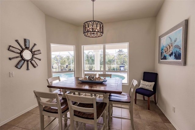 tiled dining room featuring a chandelier