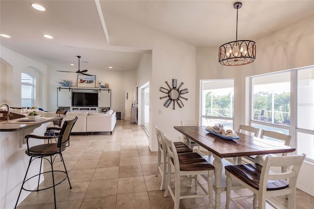 tiled dining area featuring ceiling fan with notable chandelier