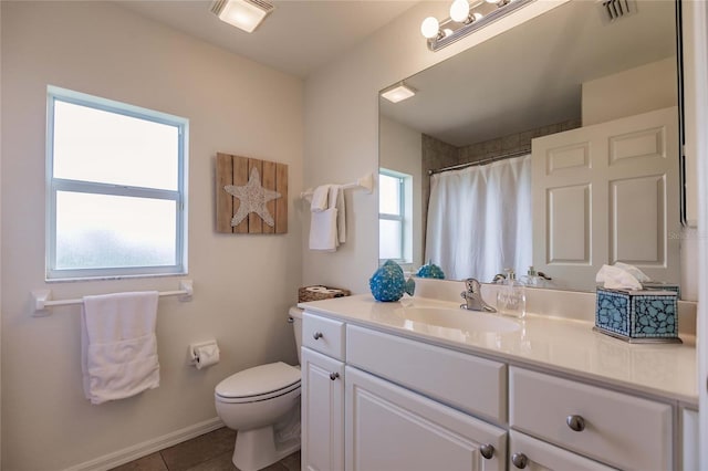 bathroom featuring tile patterned floors, plenty of natural light, vanity, and toilet