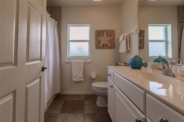 bathroom featuring tile patterned flooring, vanity, a healthy amount of sunlight, and toilet