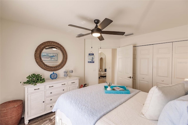 bedroom with ceiling fan, dark wood-type flooring, and a closet