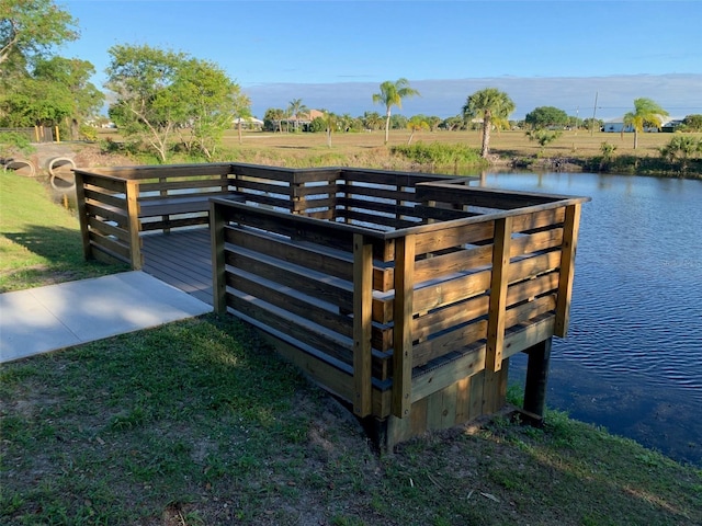 surrounding community featuring a water view and a lawn