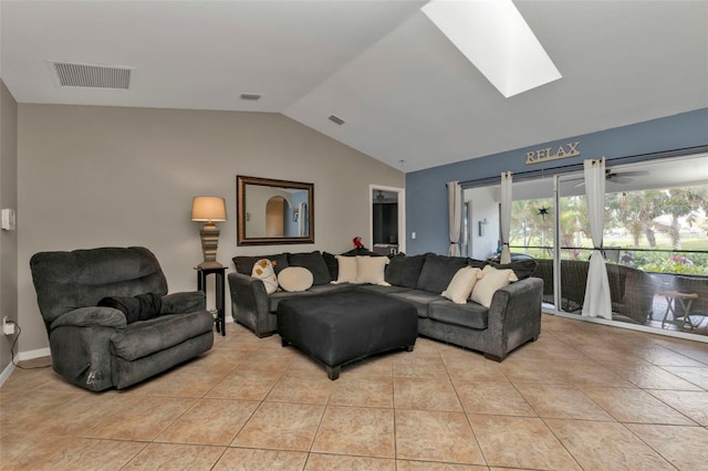 living room with lofted ceiling with skylight and light tile patterned floors