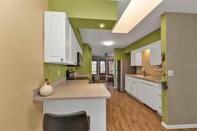 kitchen featuring ceiling fan, sink, stainless steel appliances, white cabinets, and light wood-type flooring