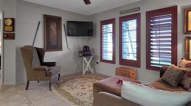 living area featuring light tile patterned floors and ceiling fan