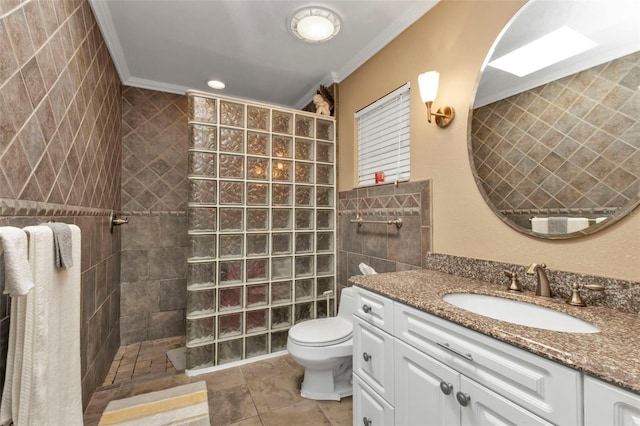 bathroom featuring a tile shower, tile patterned flooring, crown molding, vanity, and tile walls