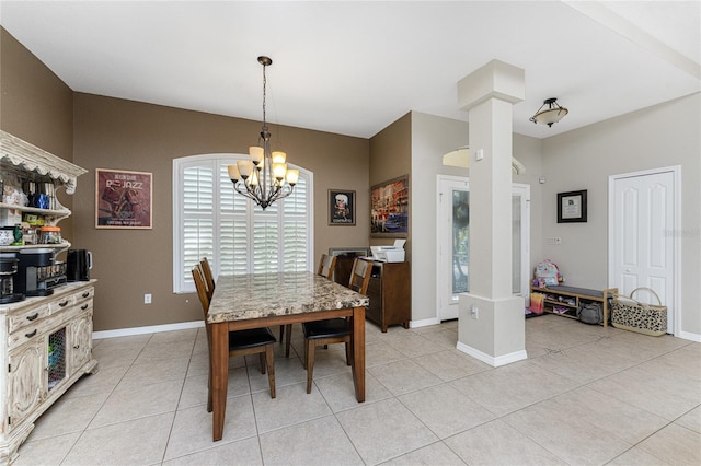 dining area with a notable chandelier, light tile patterned floors, and ornate columns