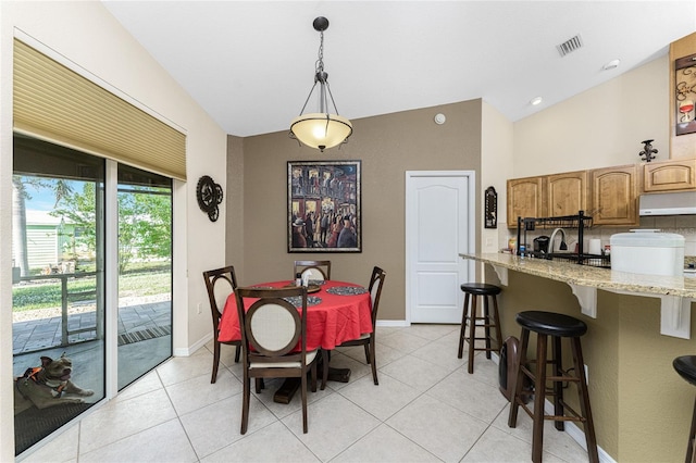 dining room featuring light tile patterned floors and lofted ceiling