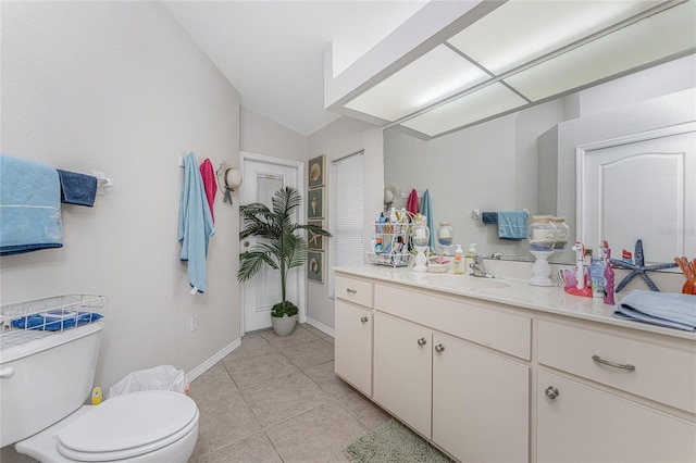 bathroom featuring tile patterned floors, vanity, vaulted ceiling, and toilet