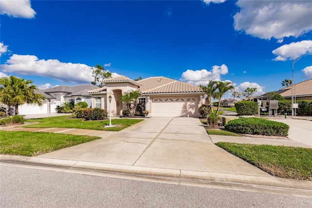 mediterranean / spanish house featuring a garage and a front lawn