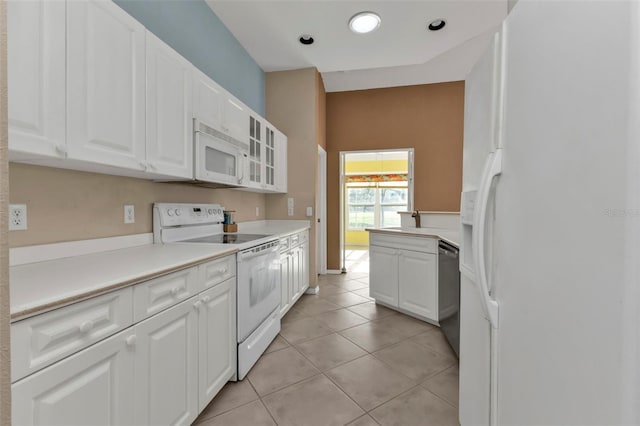 kitchen featuring light tile patterned floors, white appliances, and white cabinetry