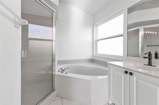 bathroom with tile patterned floors, vanity, and shower with separate bathtub