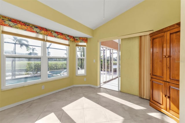 interior space featuring light tile patterned floors, lofted ceiling, and a healthy amount of sunlight