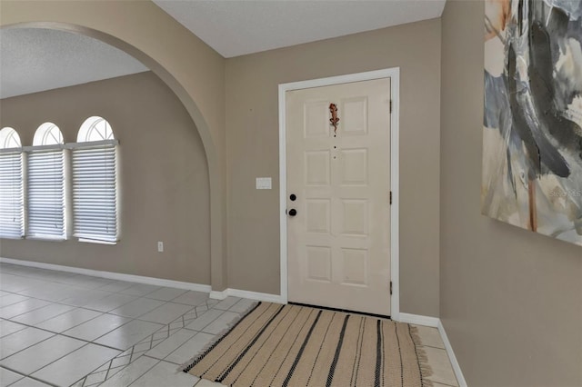 foyer entrance featuring light tile patterned floors and a textured ceiling