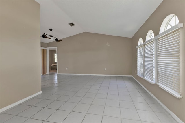 tiled empty room with ceiling fan, plenty of natural light, and vaulted ceiling