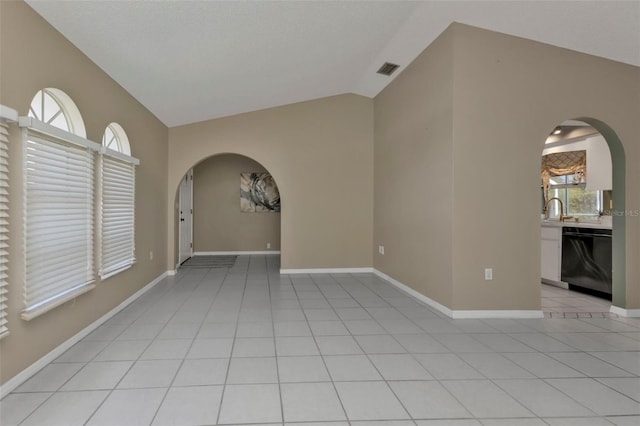 tiled empty room with sink and vaulted ceiling