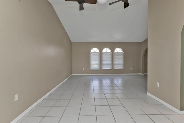 spare room with light tile patterned floors, high vaulted ceiling, and ceiling fan