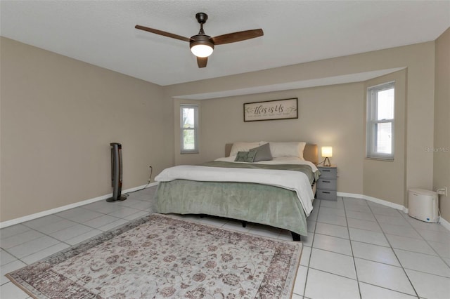 tiled bedroom featuring multiple windows and ceiling fan