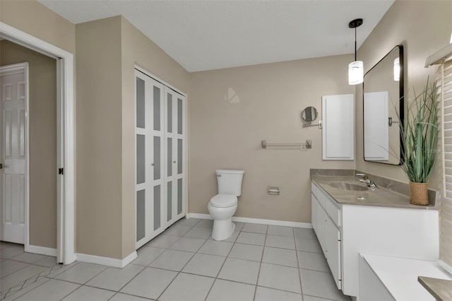 bathroom with toilet, a textured ceiling, vanity, and tile patterned floors