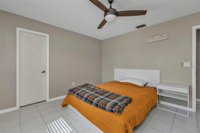 bedroom with light tile patterned floors, a textured ceiling, and ceiling fan