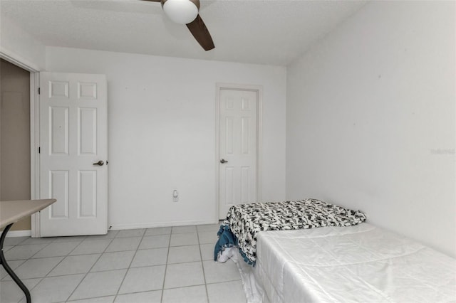 bedroom featuring light tile patterned floors, a textured ceiling, and ceiling fan