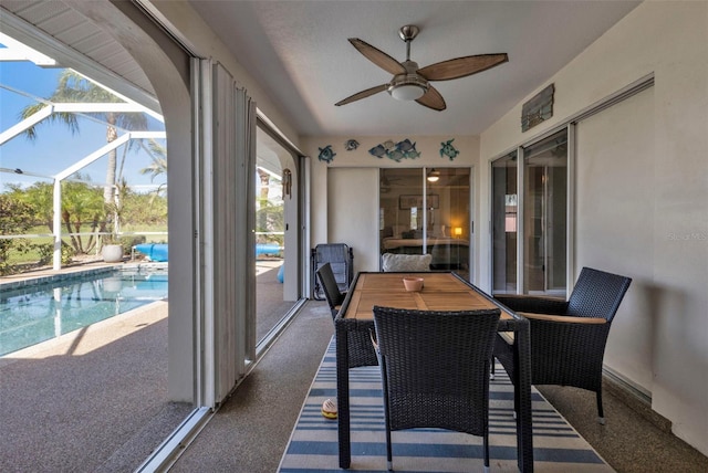 sunroom / solarium with ceiling fan, a healthy amount of sunlight, and a pool