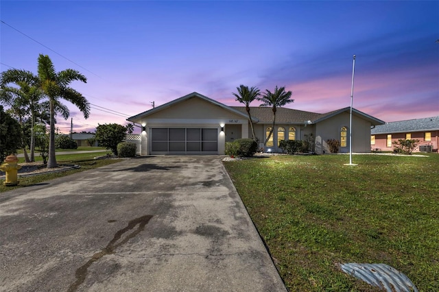 ranch-style house featuring a lawn and a garage