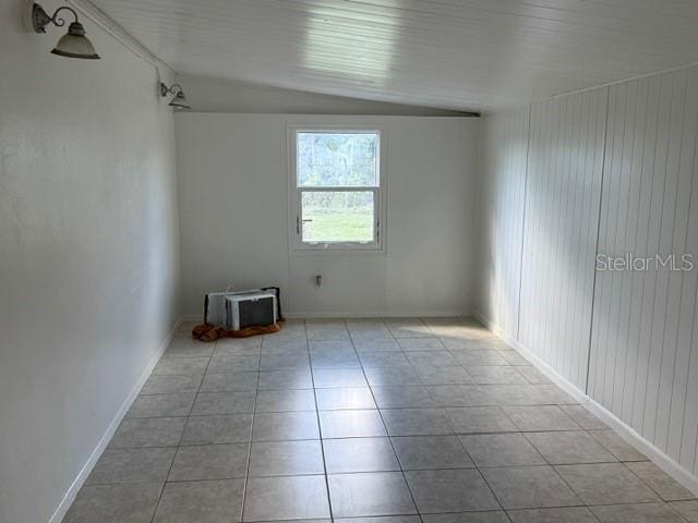 tiled spare room with lofted ceiling