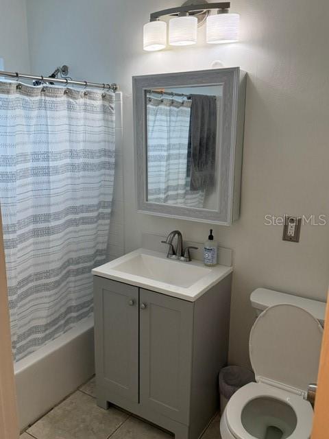 full bathroom with tile patterned flooring, vanity, shower / bath combo, and toilet